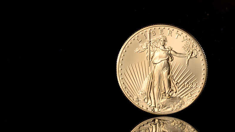 A close-up of a gold coin on a black surface