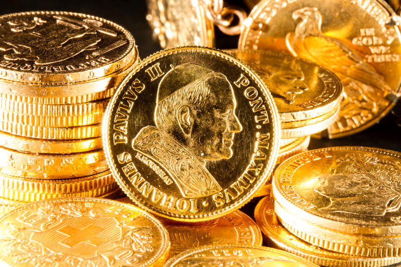 A Pile Of Gold Coins Stacked Next To Each Other, Representing Gold Investments And The Future Of The Gold Market.